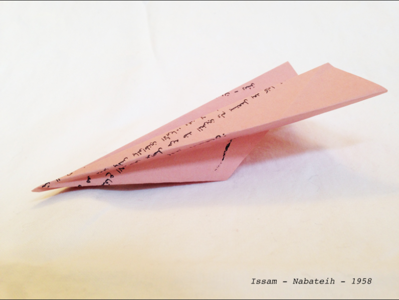 Rosa Papierflieger mit handschriftlichen Notizen auf Arabisch in schwarzer Farbe. Rechts unten im Bild die Worte: Issam – Nabateih – 1958.